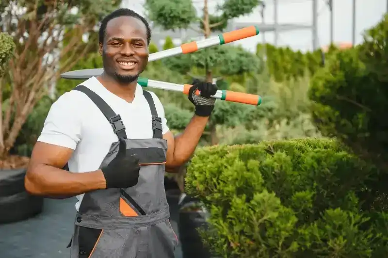 a landscaper with garden shears doing a thumbs up